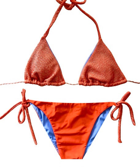 Bikini de cortina de estructura naranja con metalizado. La braguita es naranja liso por delante y del tejido con estructura como la parte de arriba por detrás.