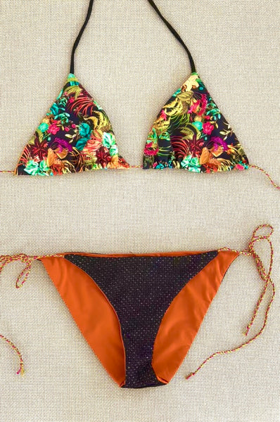 Bikini triangular estampado de flores con fondo negro y braguita de piqué negra con lurex oro.