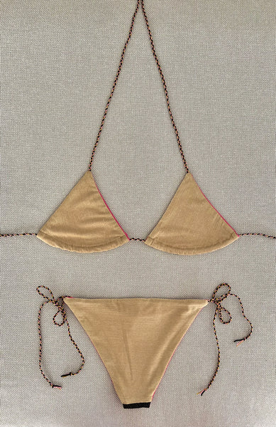 Bikini triangular de lurex oro con la braguita por la parte de delante de pique negro y lurex oro y la de atrás con lurex oro.