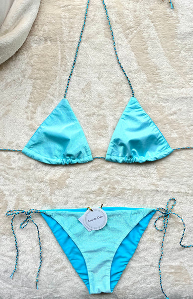 Bikini triangular de color azul celeste con lurex. La braguita a juego.