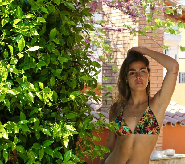 Bikini triangular estampado de flores con fondo negro y braguita de piqué negra con lurex oro.