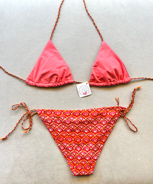 Conjunto de Bikini y Mini pareo de crepé estampado geométrico étnico de tonos naranjas con puntos dorados.