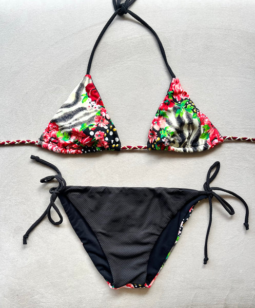 Bikini triangular estampado de flores y topos. Braguita triangular de piqué negro por delante y estampada por detrás.