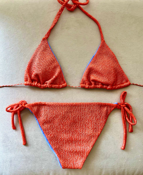 Bikini de cortina de estructura naranja con metalizado. La braguita es naranja liso por delante y del tejido con estructura como la parte de arriba por detrás.