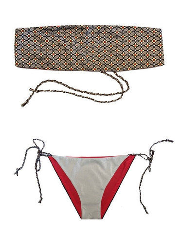 Bikini tipo bandeau estampado geométrico con puntos laminados plateados. Braguita triangular de lurex plata por delante y negro por detrás.