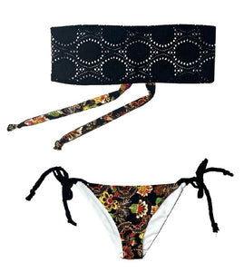 Bikini bandeau de crochet negro. Braguita triangular estampada por delante y detrás con estampado de flores y fondo negro.