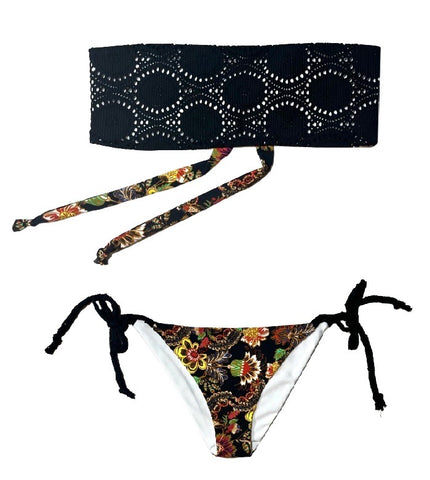 Bikini bandeau de crochet negro. Braguita triangular estampada por delante y detrás con estampado de flores y fondo negro.